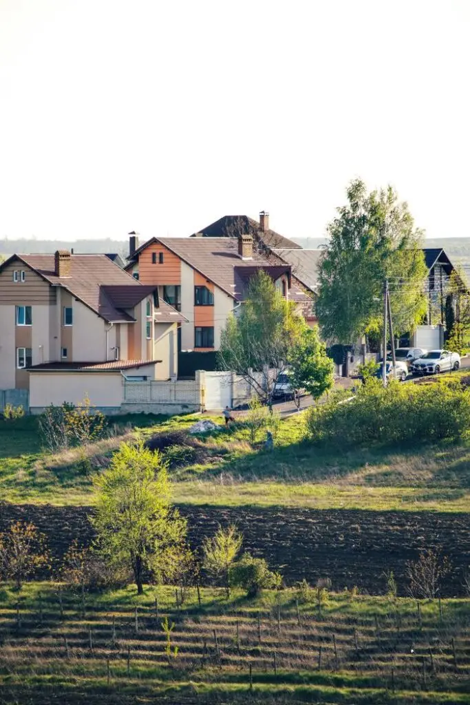 A serene view of suburban homes surrounded by greenery under a bright sky.